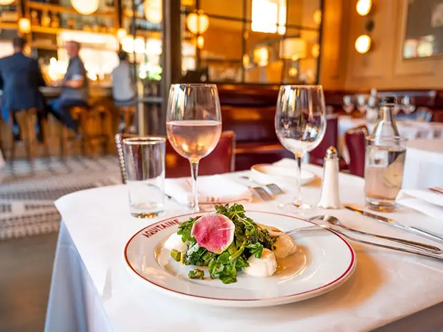 restaurant table with food and wine in it