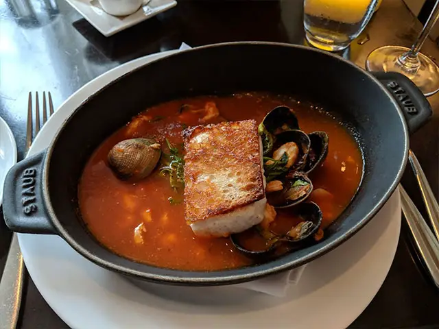 soup filled with oysters and fish on top